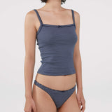 A model wearing a navy blue and white striped tank top and thong shot against a plain light gray background.