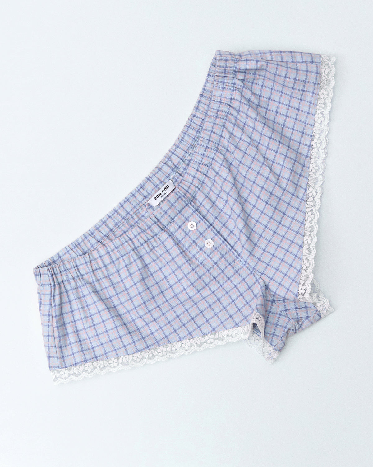 Blue checkered boxer shorts with lace trim on a light gray background