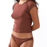 Woman wearing a brown crop top and underwear set on a white background