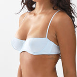 Light blue bra worn by a person on a white background
