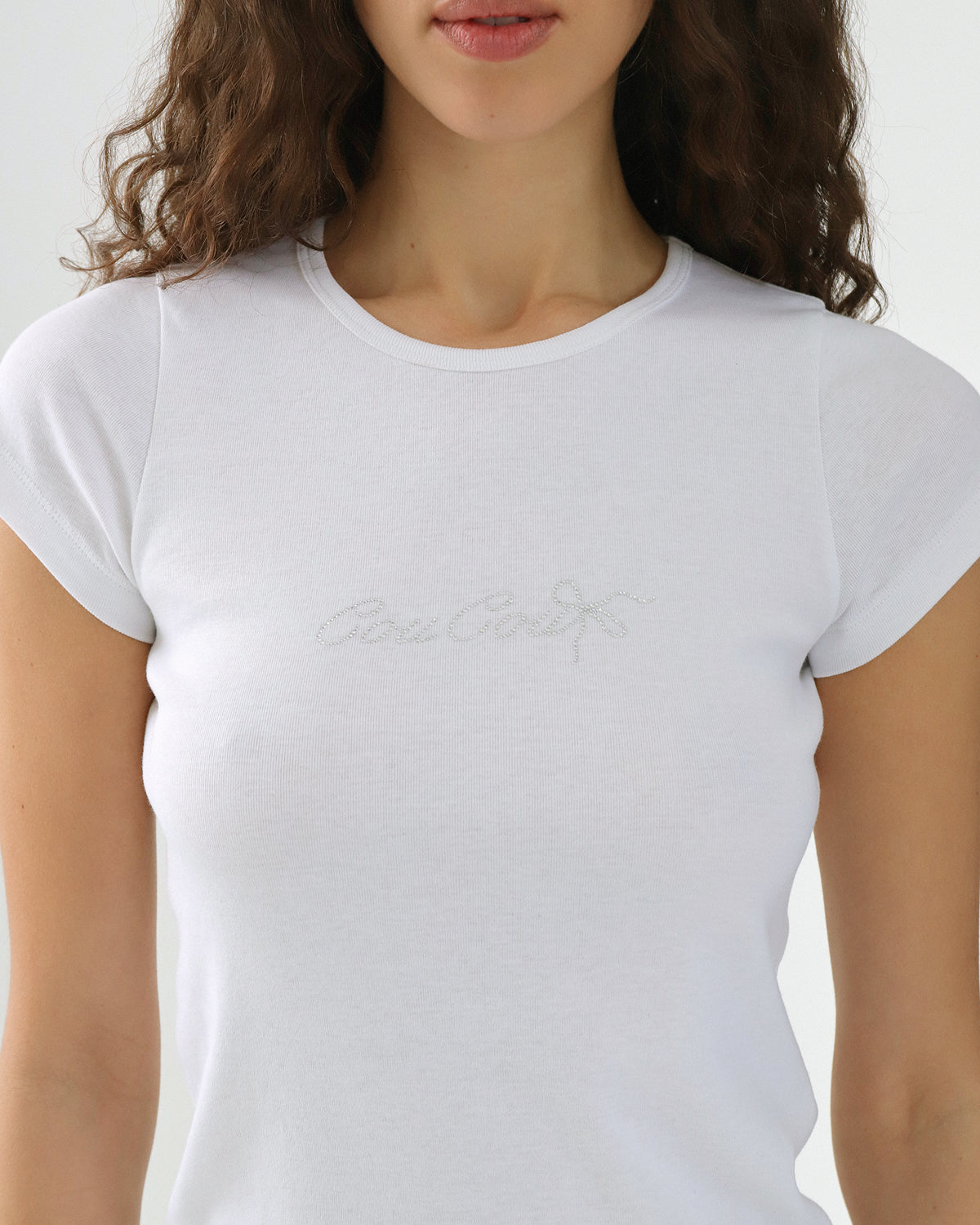 White t-shirt with a brand logo worn by a person on a white background