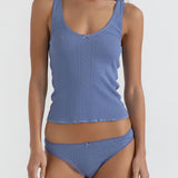 Woman wearing a blue tank top and brief on a white background