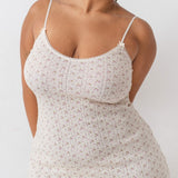 Woman wearing a floral dress against a white background