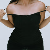 Woman wearing a black dress against a plain background