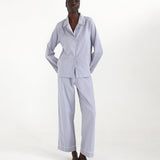Person wearing a blue checkered pajama set on a white background