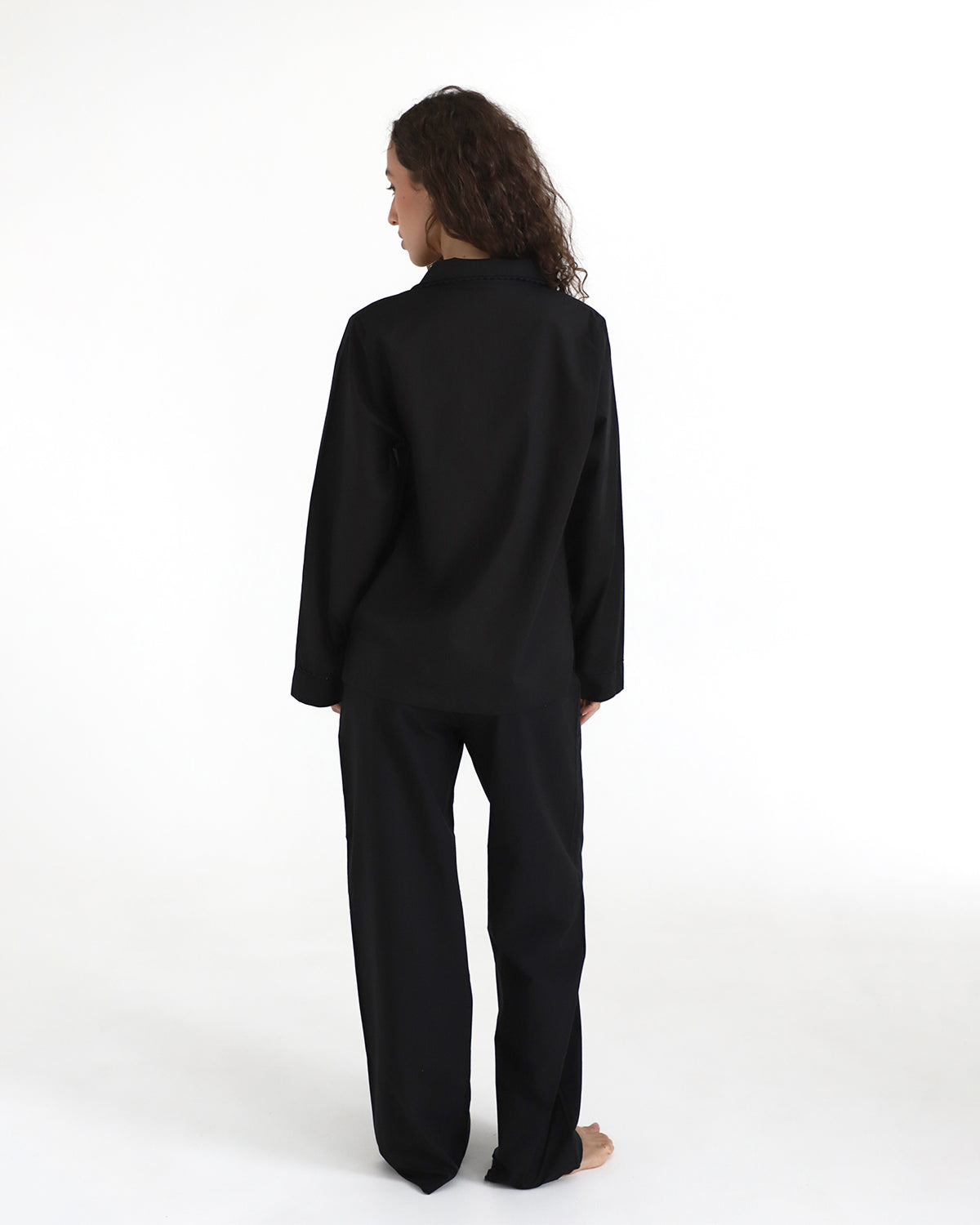 Person wearing a black outfit on a white background