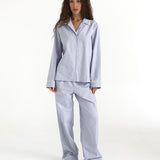 Woman wearing a blue checkered pajama set on a white background