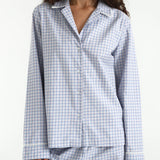 Woman wearing a blue and white checkered pajama set on a white background