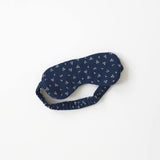 Navy blue sleep mask with white floral pattern on a white background