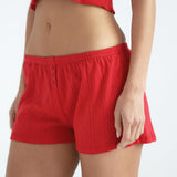 Red shorts worn by a person on a white background