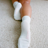 White socks worn on a carpeted floor