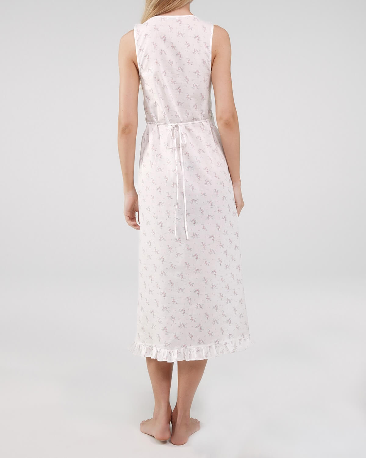 Woman wearing a white lace dress on a plain background