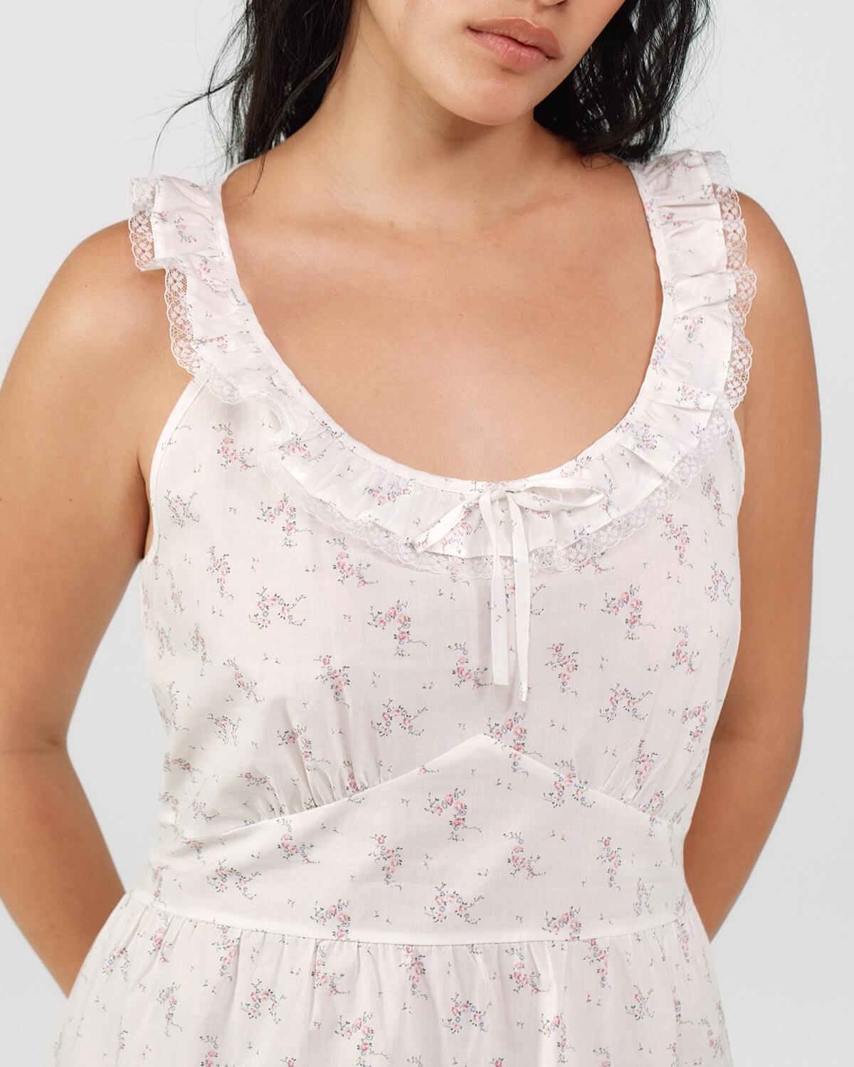 White floral dress worn by a model on a light gray background
