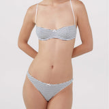 A woman modeling a bra and thong with thin horizontal navy and white stripes.
