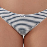 Close-up of a person wearing underwear with narrow navy blue horizontal stripes on a white base and a small white bow at the center front.