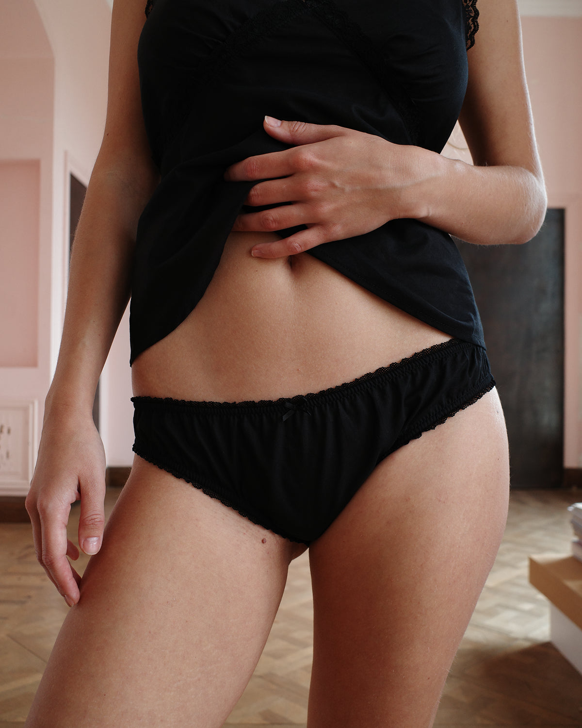 Person wearing black underwear in an indoor setting