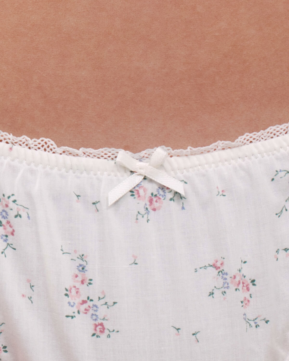 Close up floral-patterned briefs with lace trim and a bow.