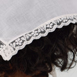 Close-up of a lace-trimmed headscarf with a neutral background